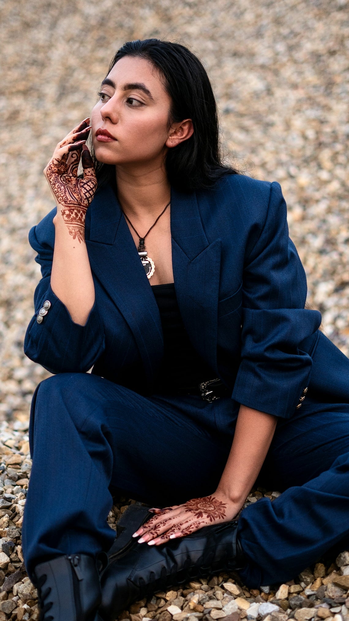 a woman sitting on the ground talking on a cell phone