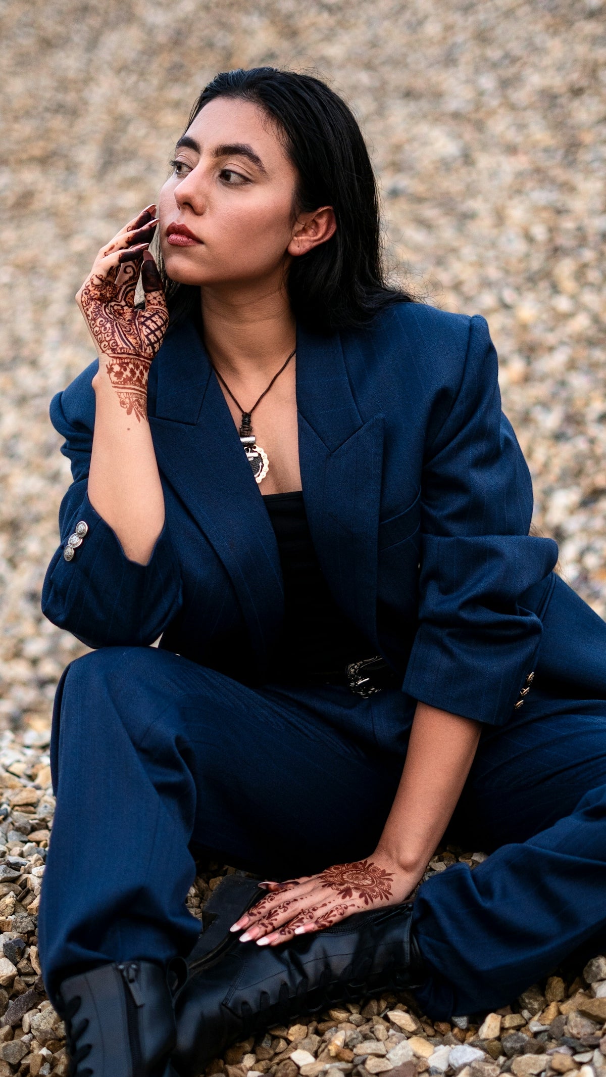a woman sitting on the ground talking on a cell phone