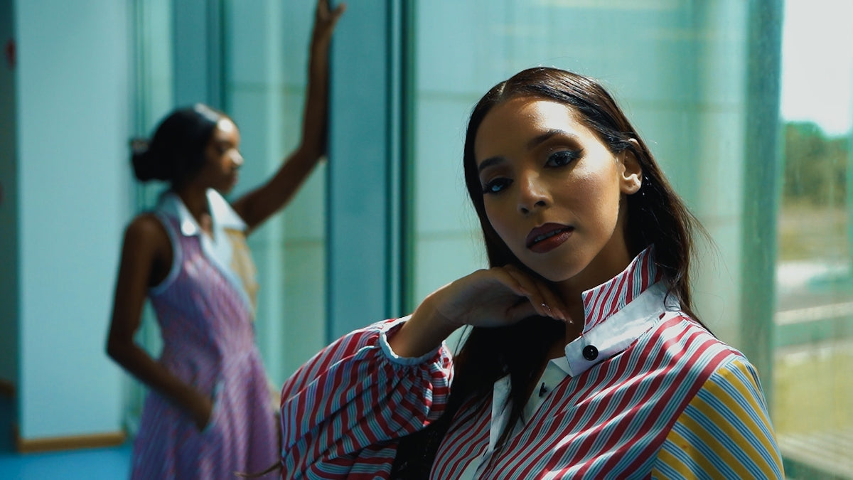a woman in a striped shirt and tie posing for a picture