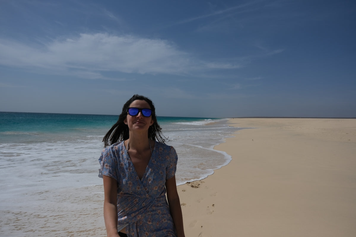 a woman standing on a beach next to the ocean