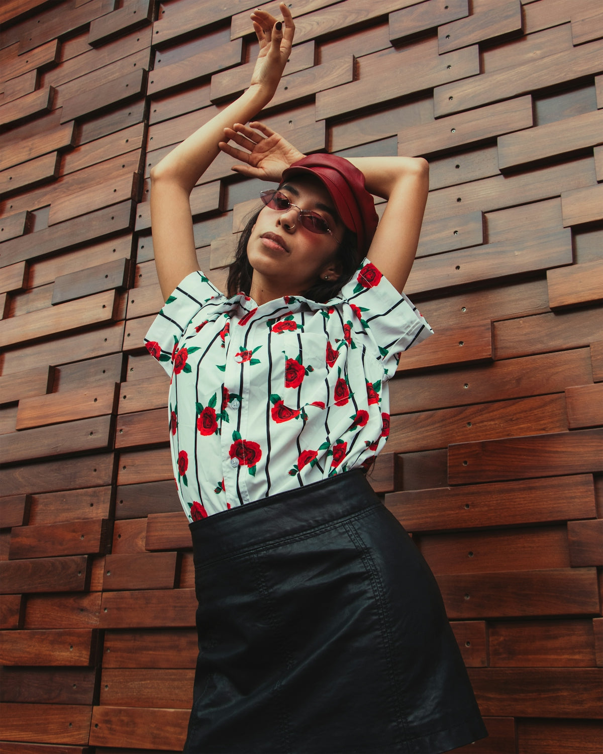 a woman standing in front of a wooden wall