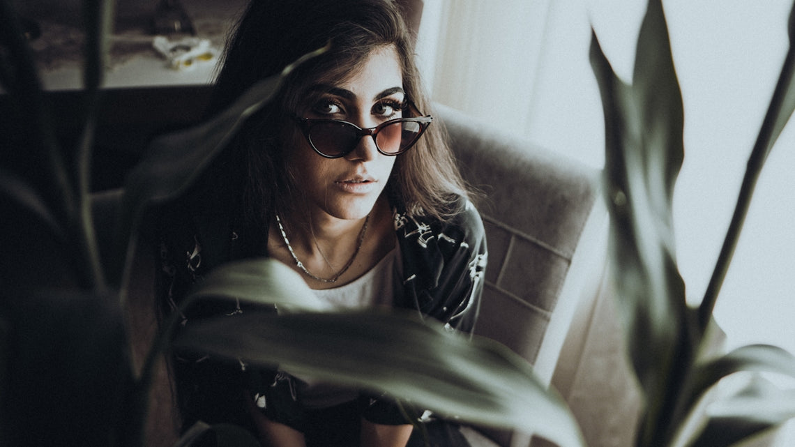 a woman sitting in a chair next to a plant
