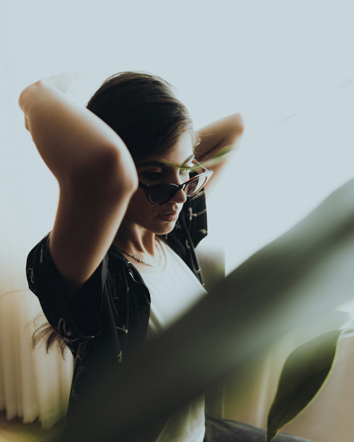 a woman wearing sunglasses sitting on a couch