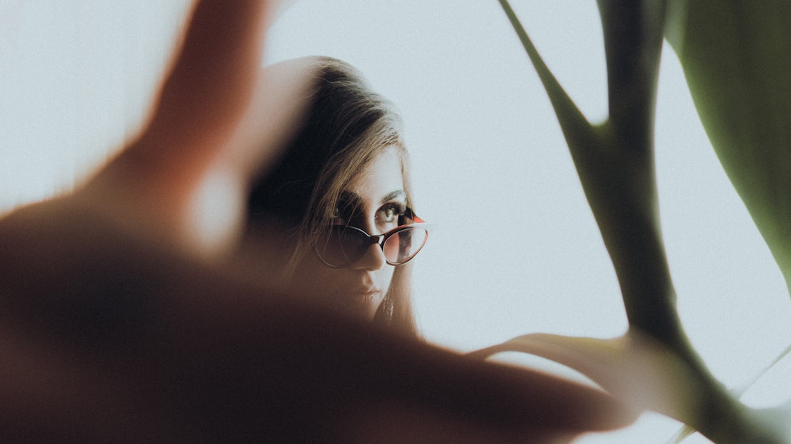 a woman with glasses looking out of a window