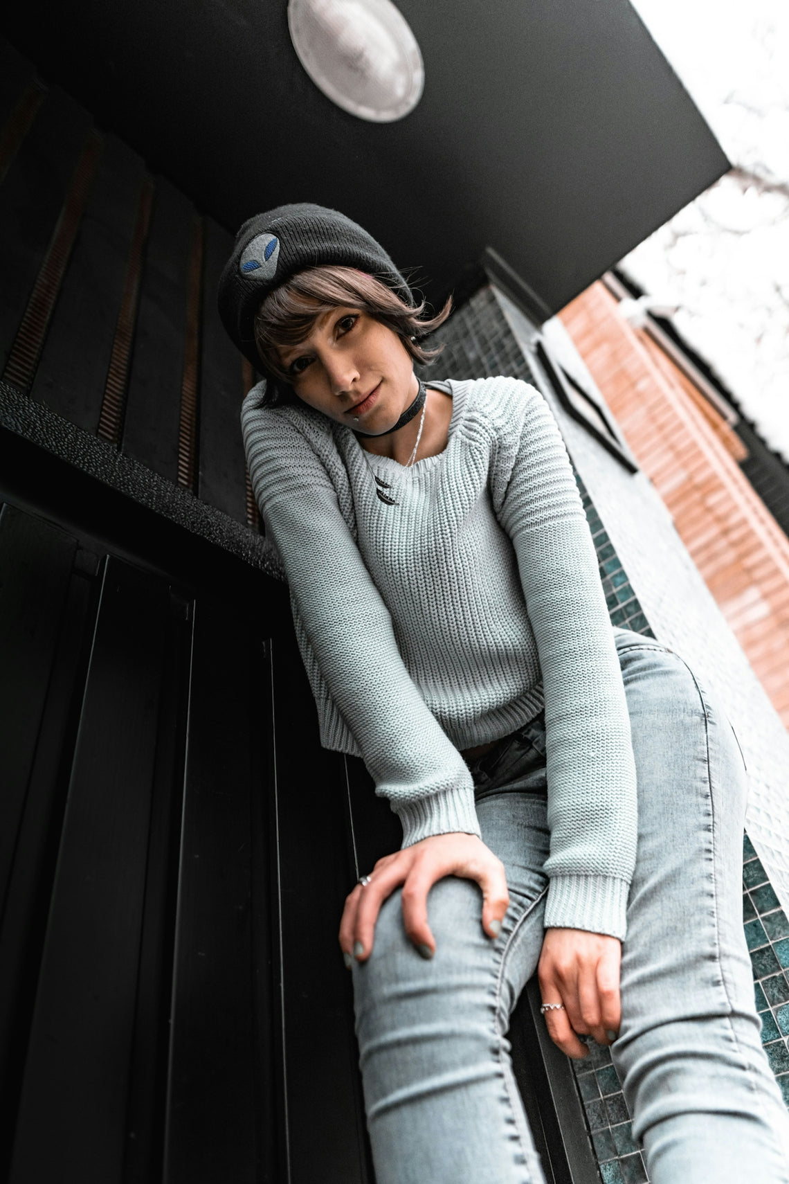 a woman sitting on a bench wearing a hat