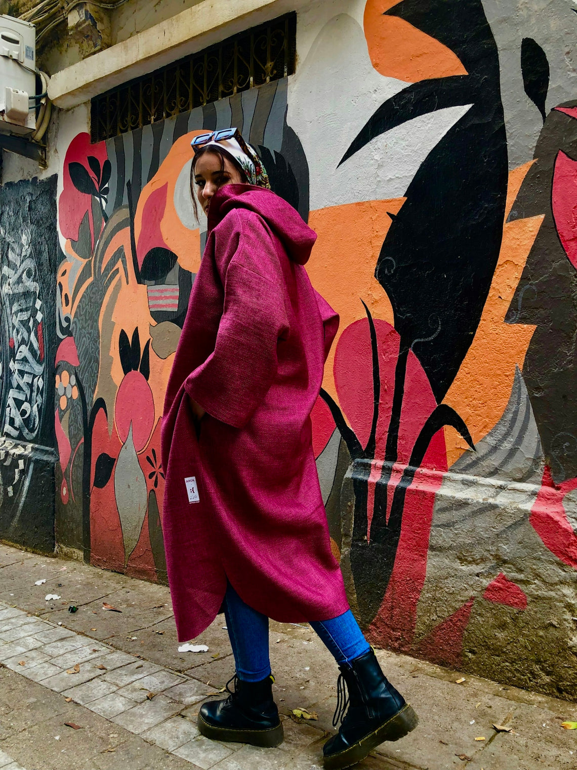 a woman in a pink coat walking down the street