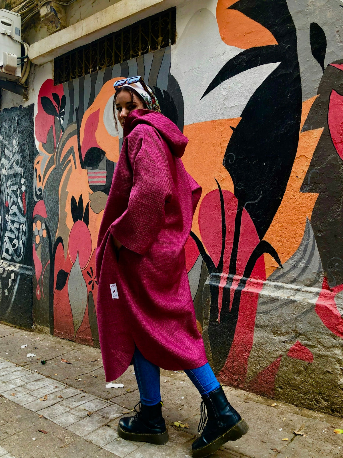 a woman in a pink coat walking down the street
