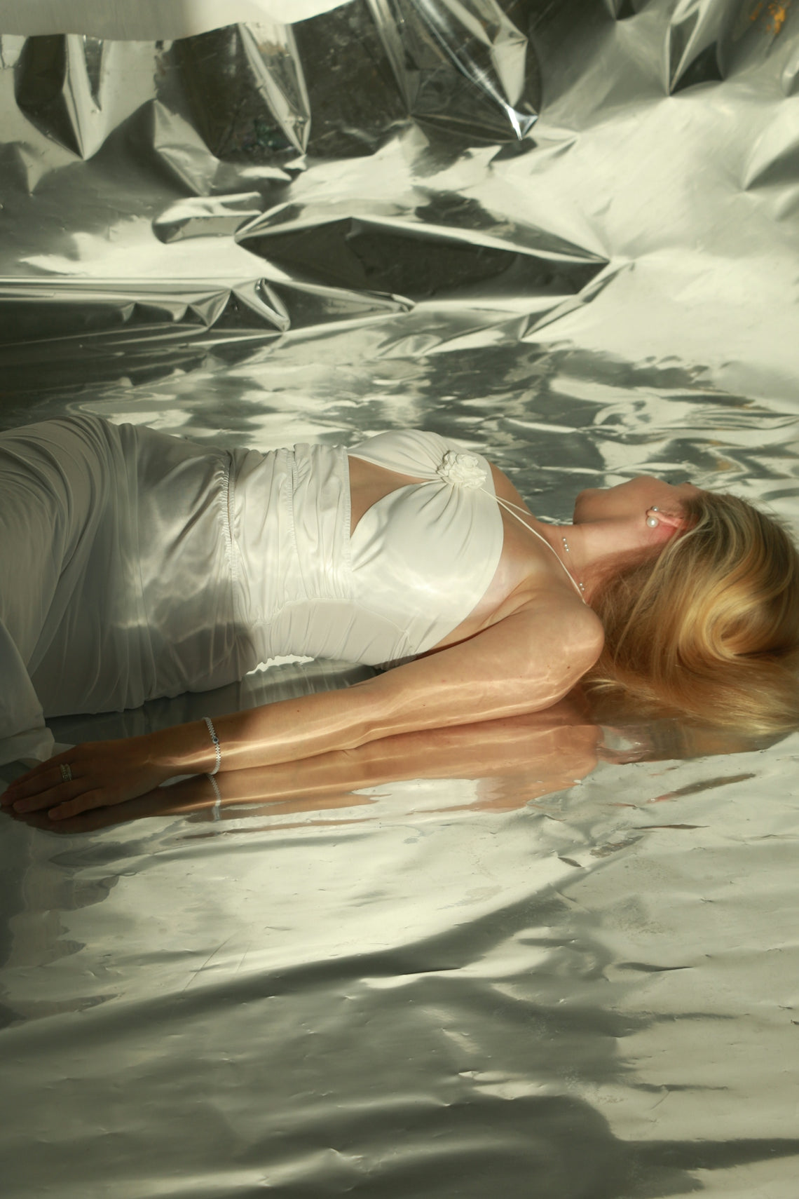 a woman laying on top of a body of water