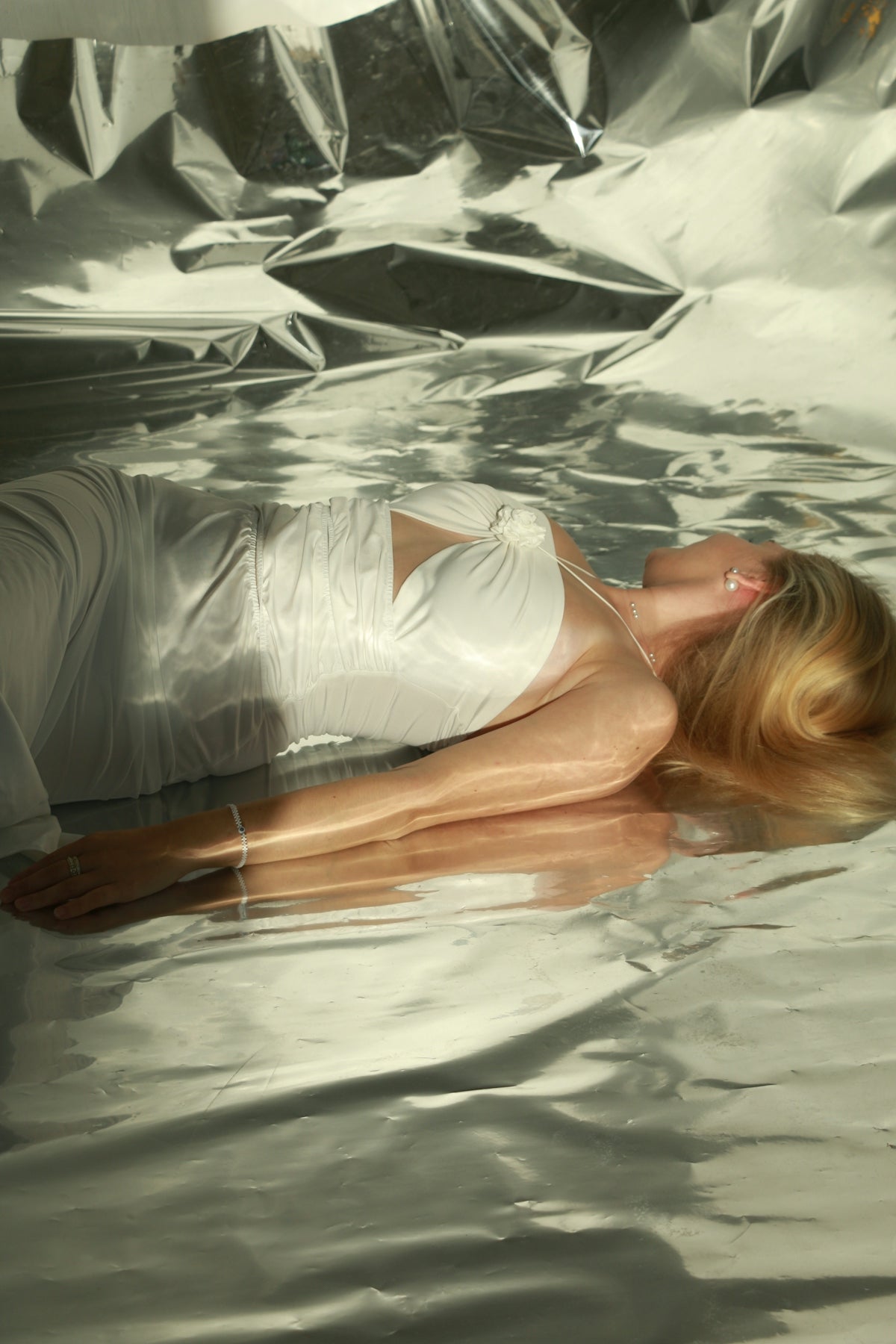 a woman laying on top of a body of water