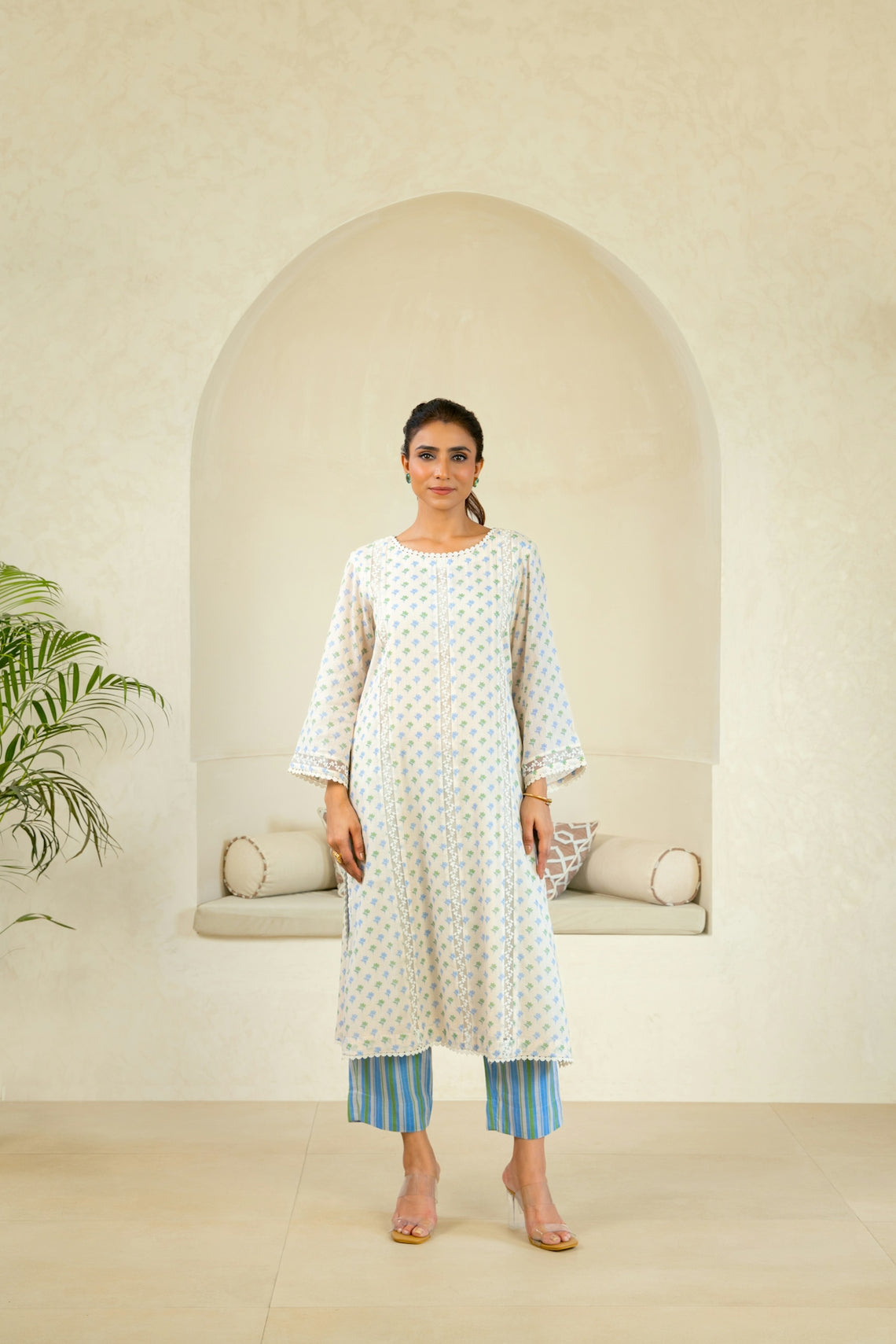 A woman standing in front of a white wall