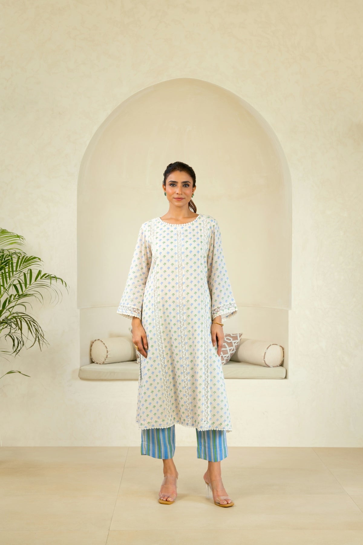 A woman standing in front of a white wall