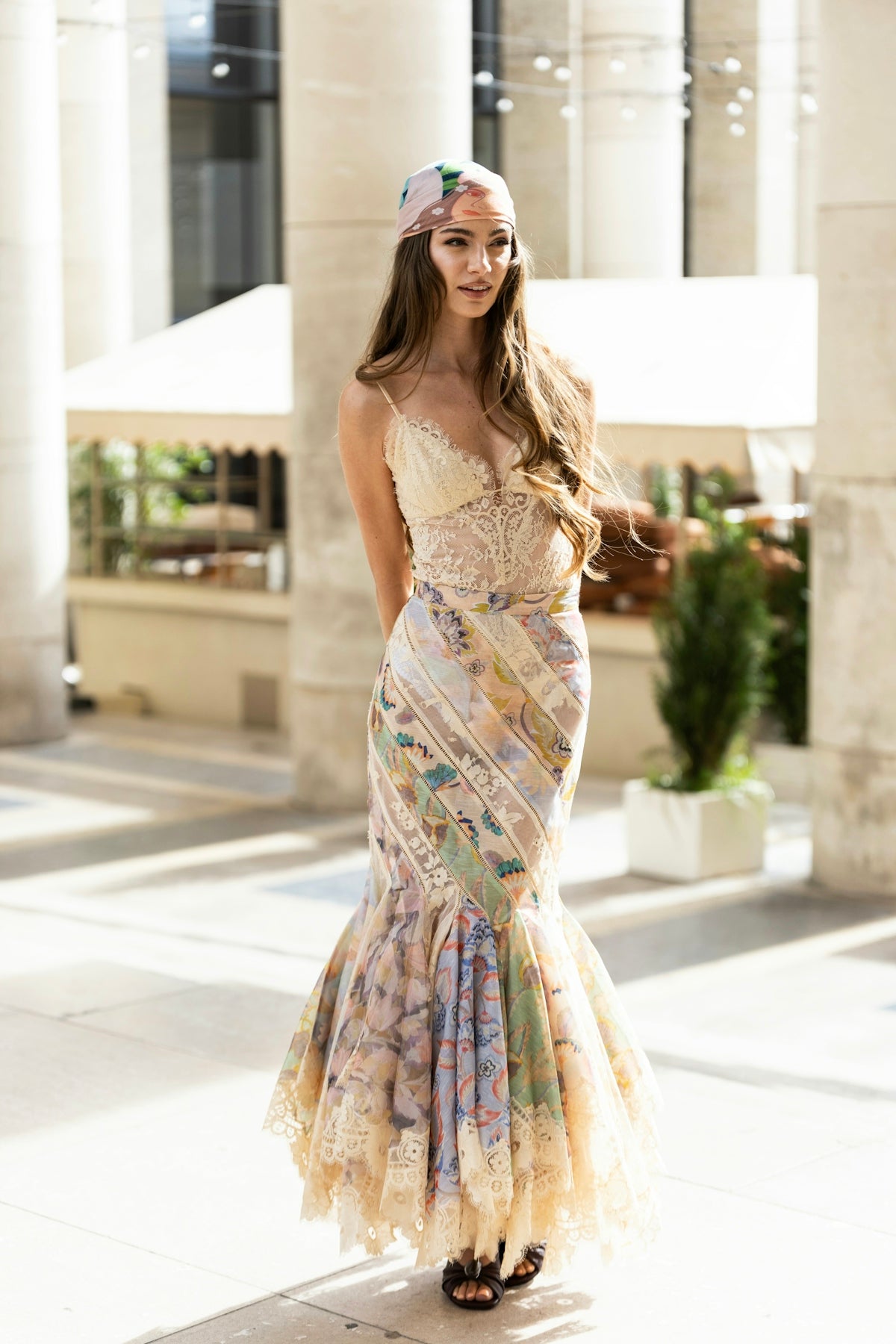 A woman in a dress standing on a sidewalk