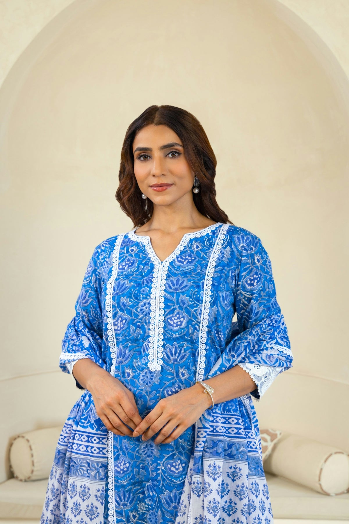 A woman standing in front of a white couch
