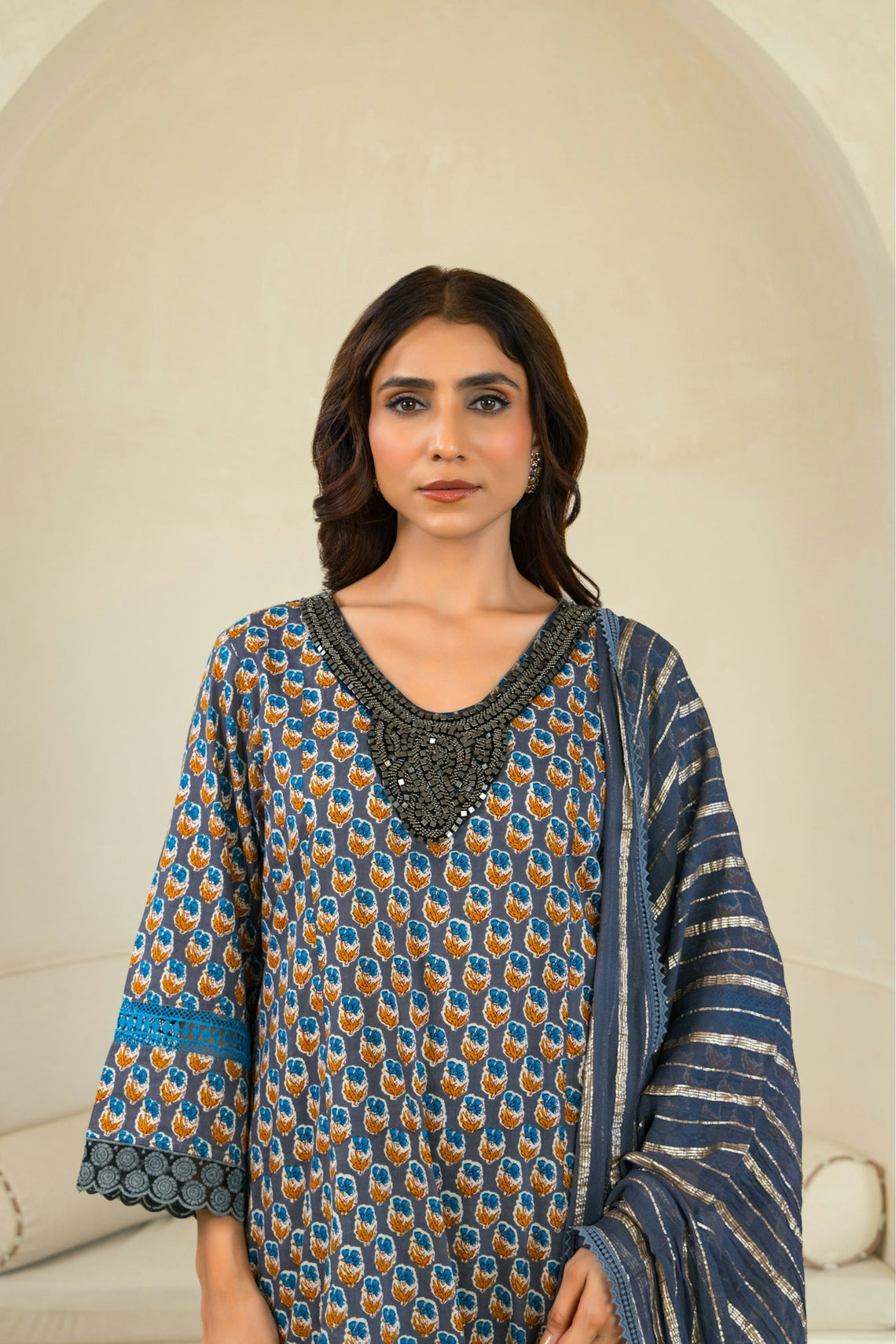 A woman standing in front of a white wall