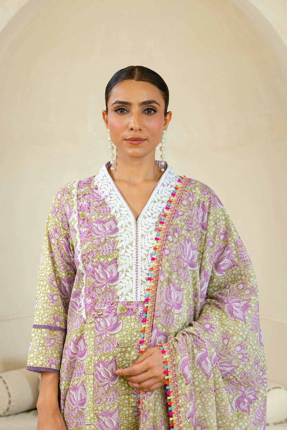 A woman standing in front of a white couch