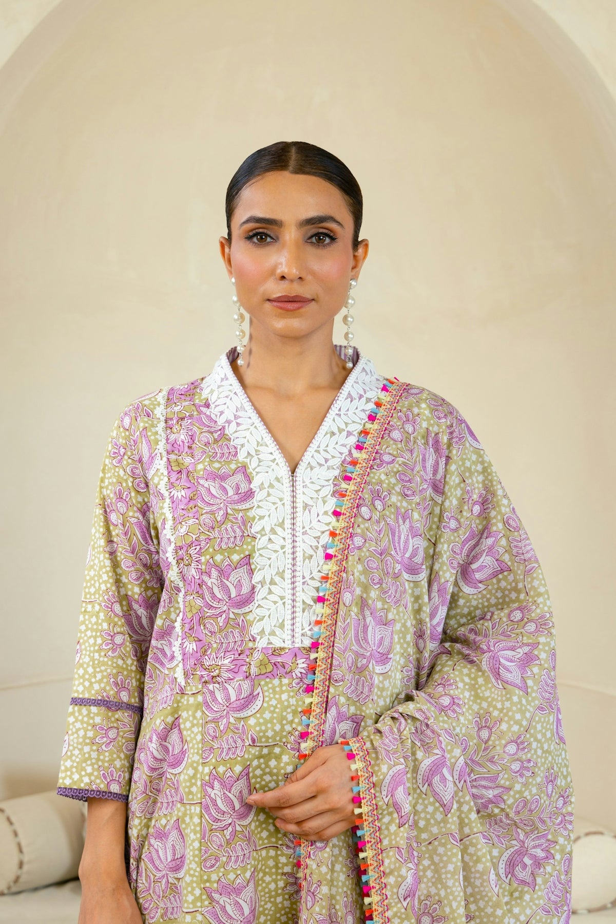 A woman standing in front of a white couch