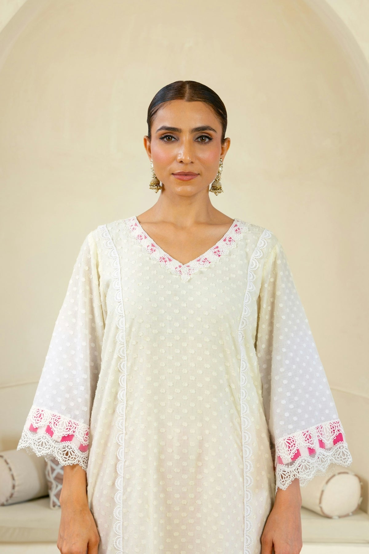 A woman standing in front of a white wall
