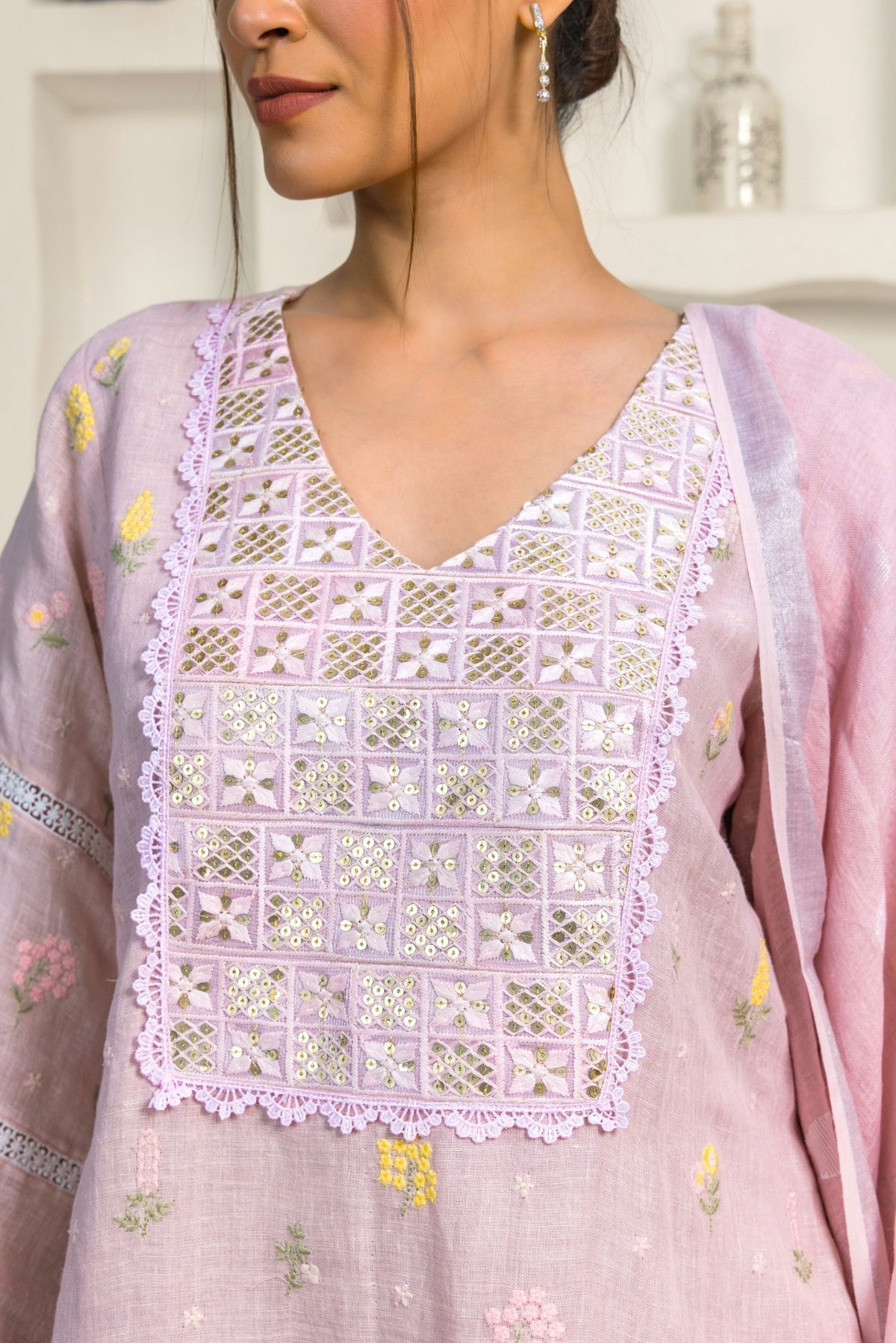 A woman wearing a pink top with a flowered design on it