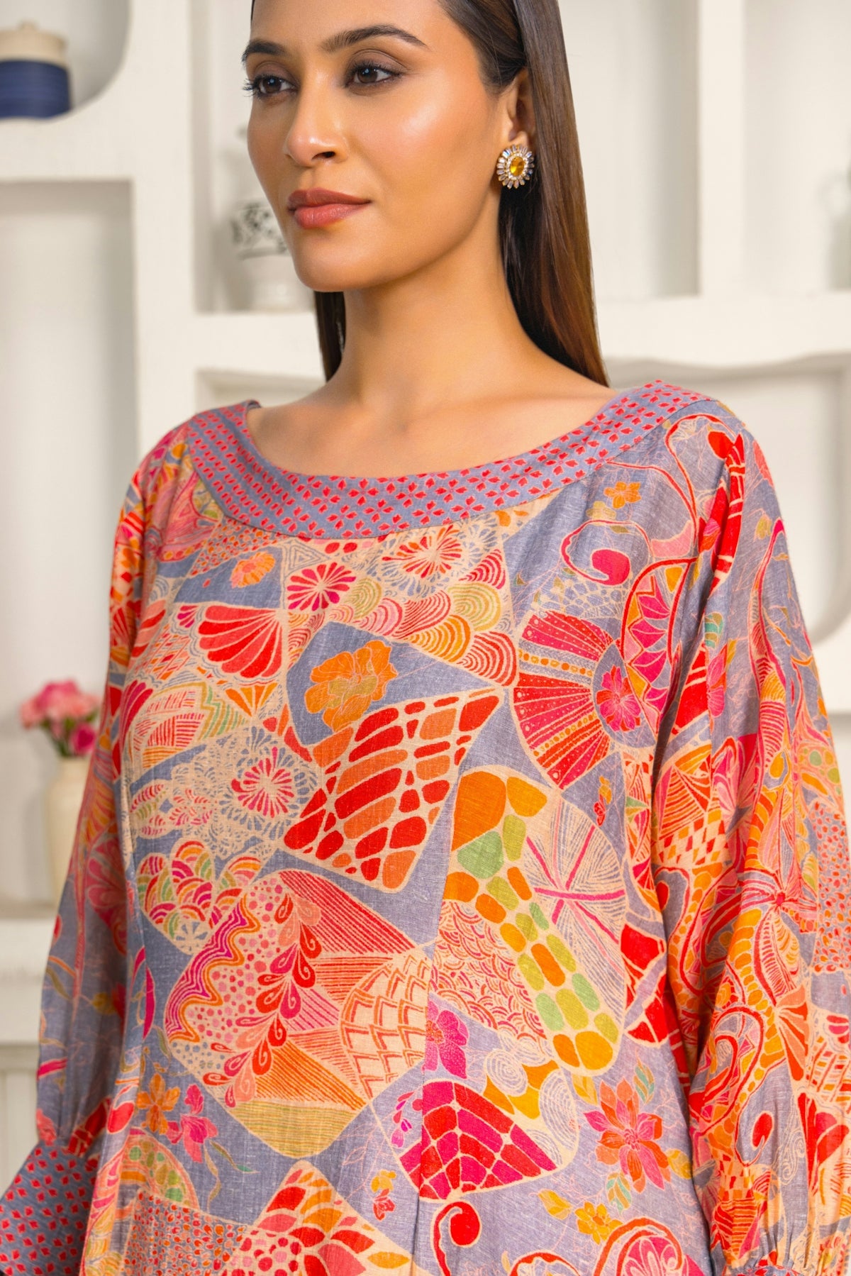 A woman standing in front of a white shelf