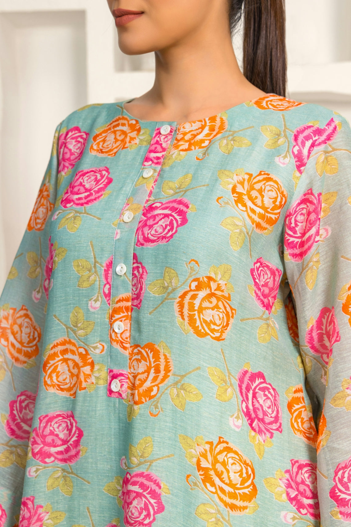 A woman with a ponytail wearing a blue top