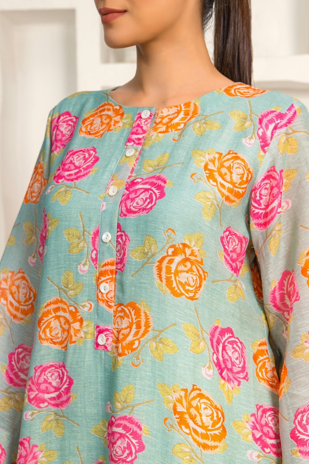 A woman with a ponytail wearing a blue top