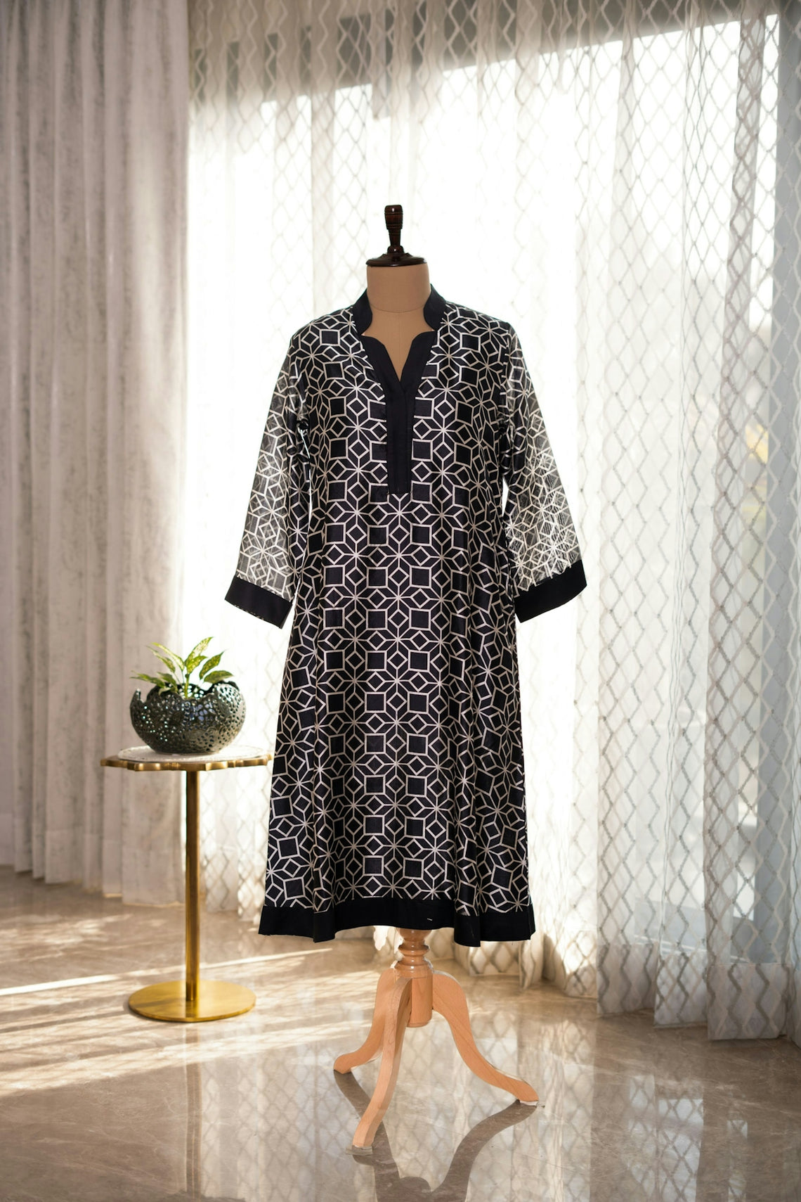 A dress on a mannequin in front of a window