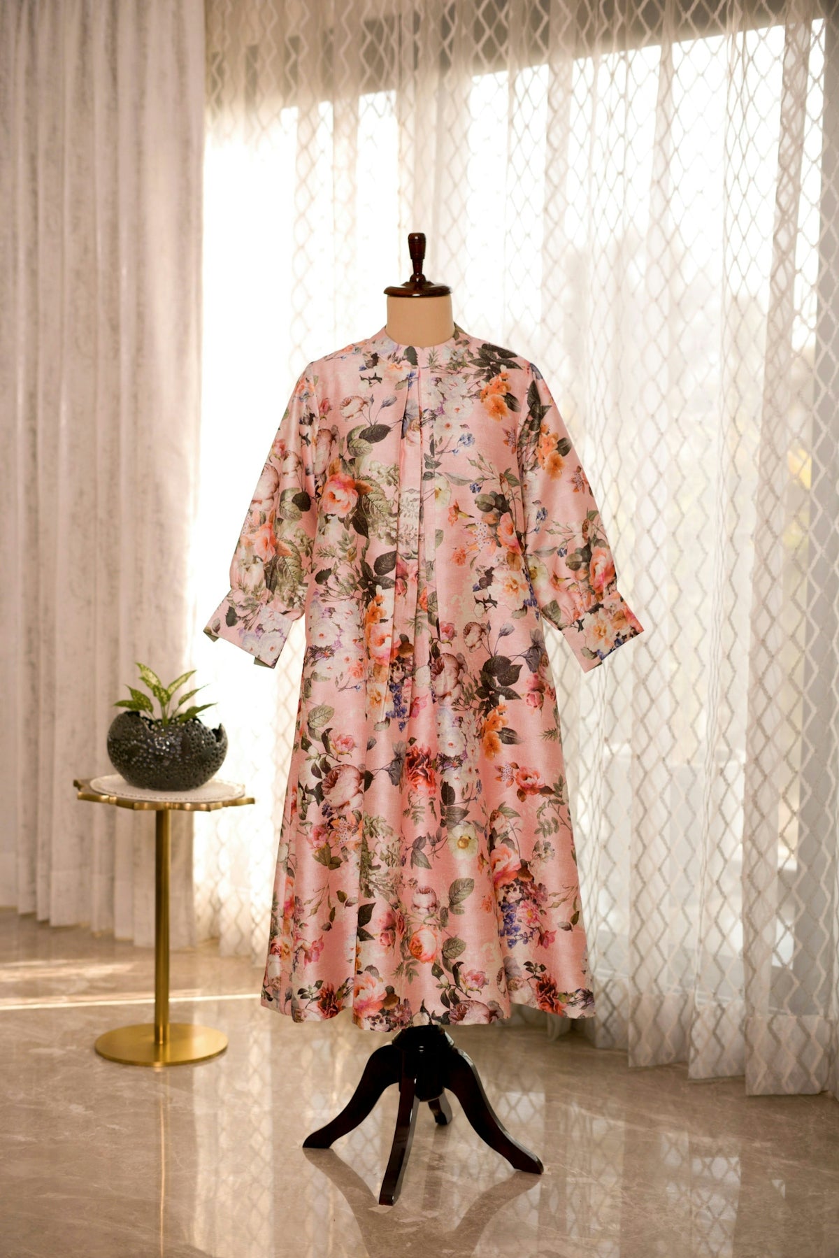 A dress on a mannequin in front of a window