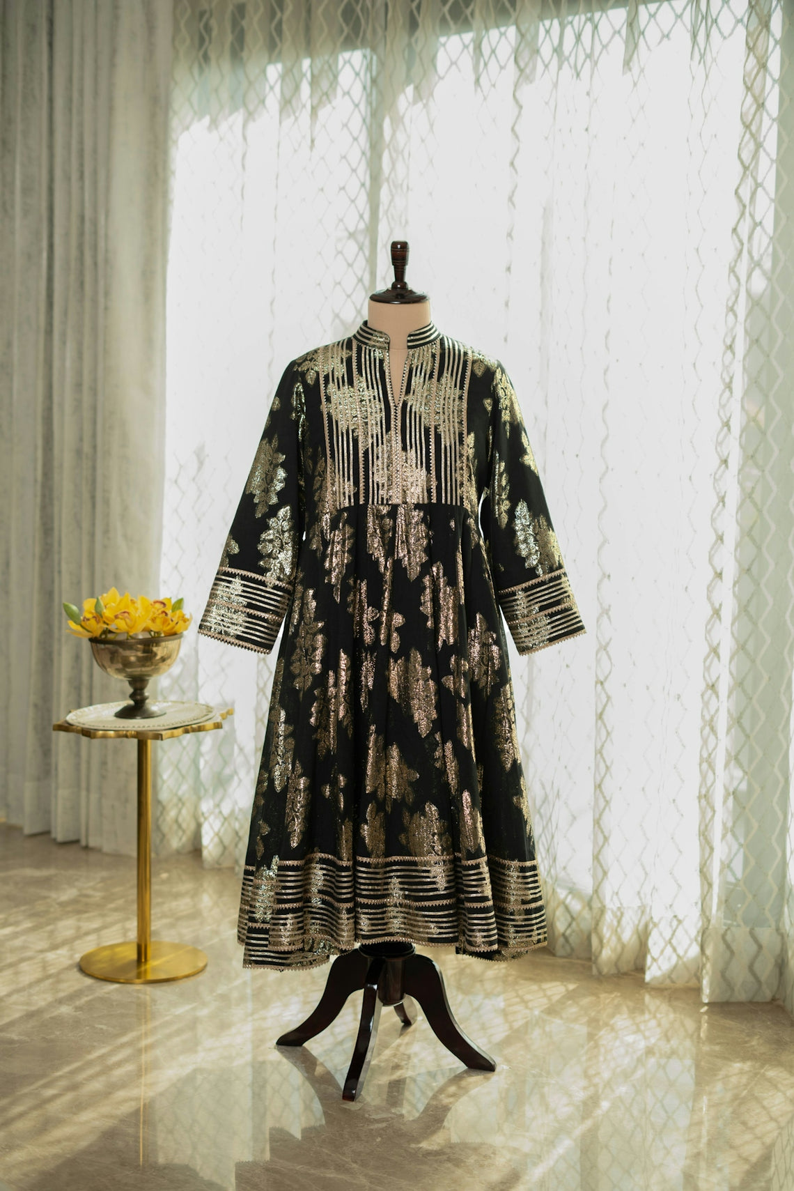 A dress on a mannequin in front of a window