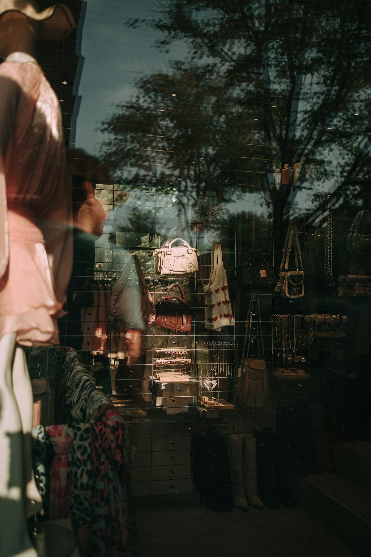 Reflection in shop window showing clothing and accessories