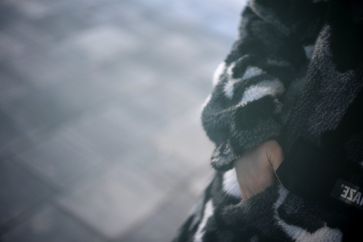 Close-up of a person wearing a patterned scarf and gloves.