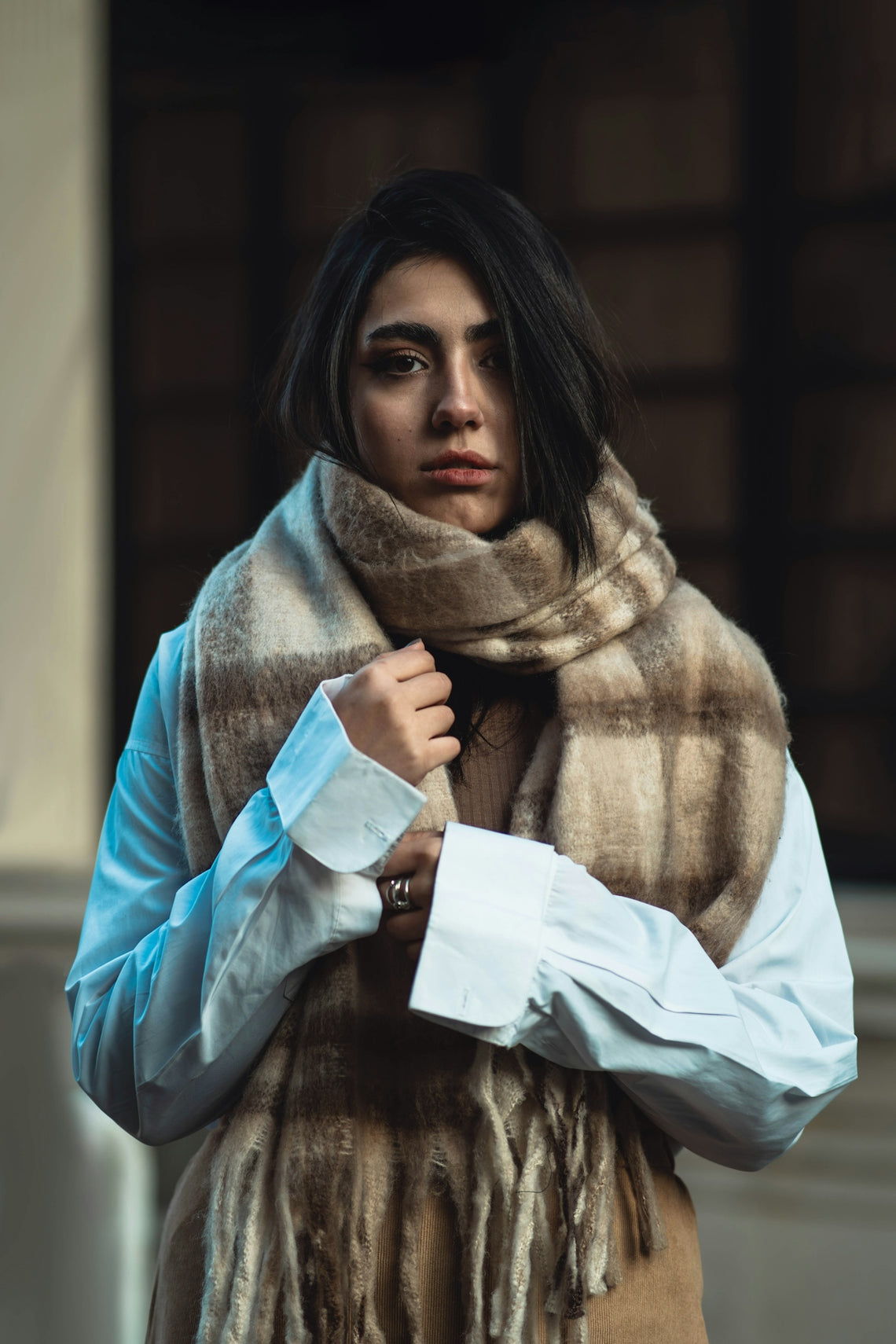 A woman wearing a scarf and white shirt