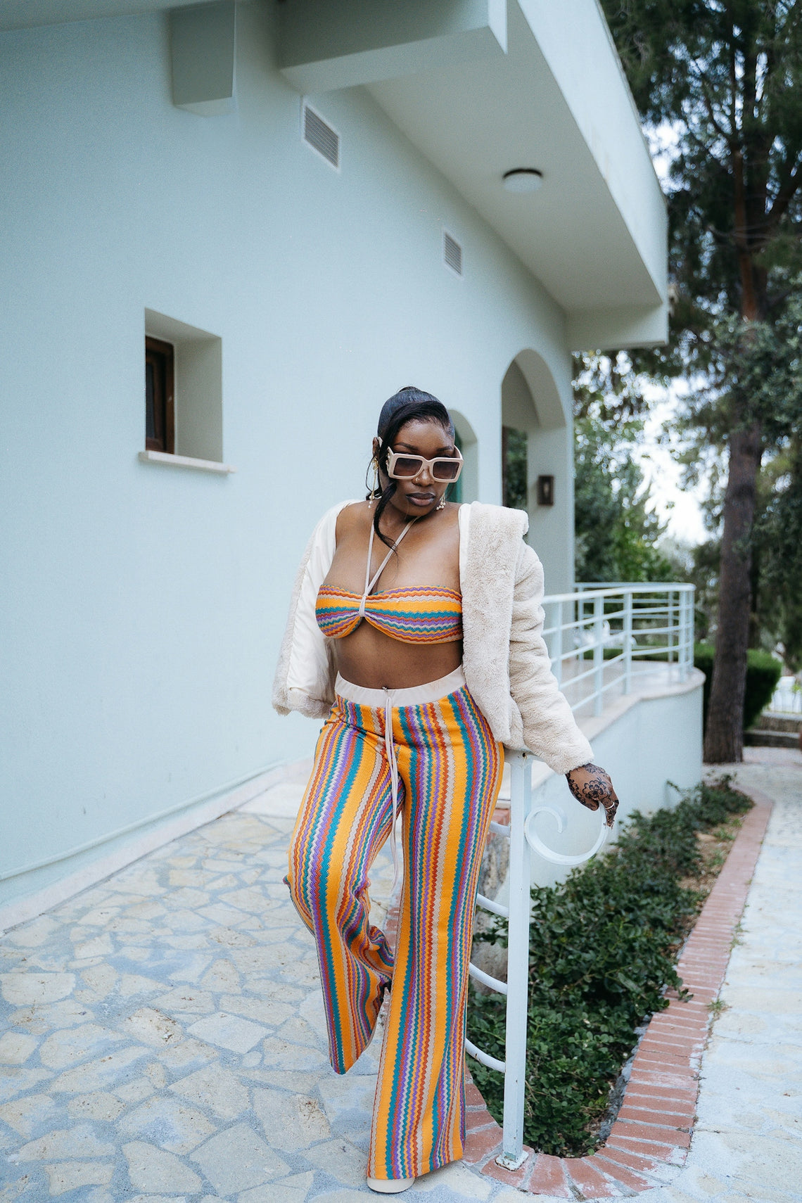 Woman in colorful striped outfit and sunglasses