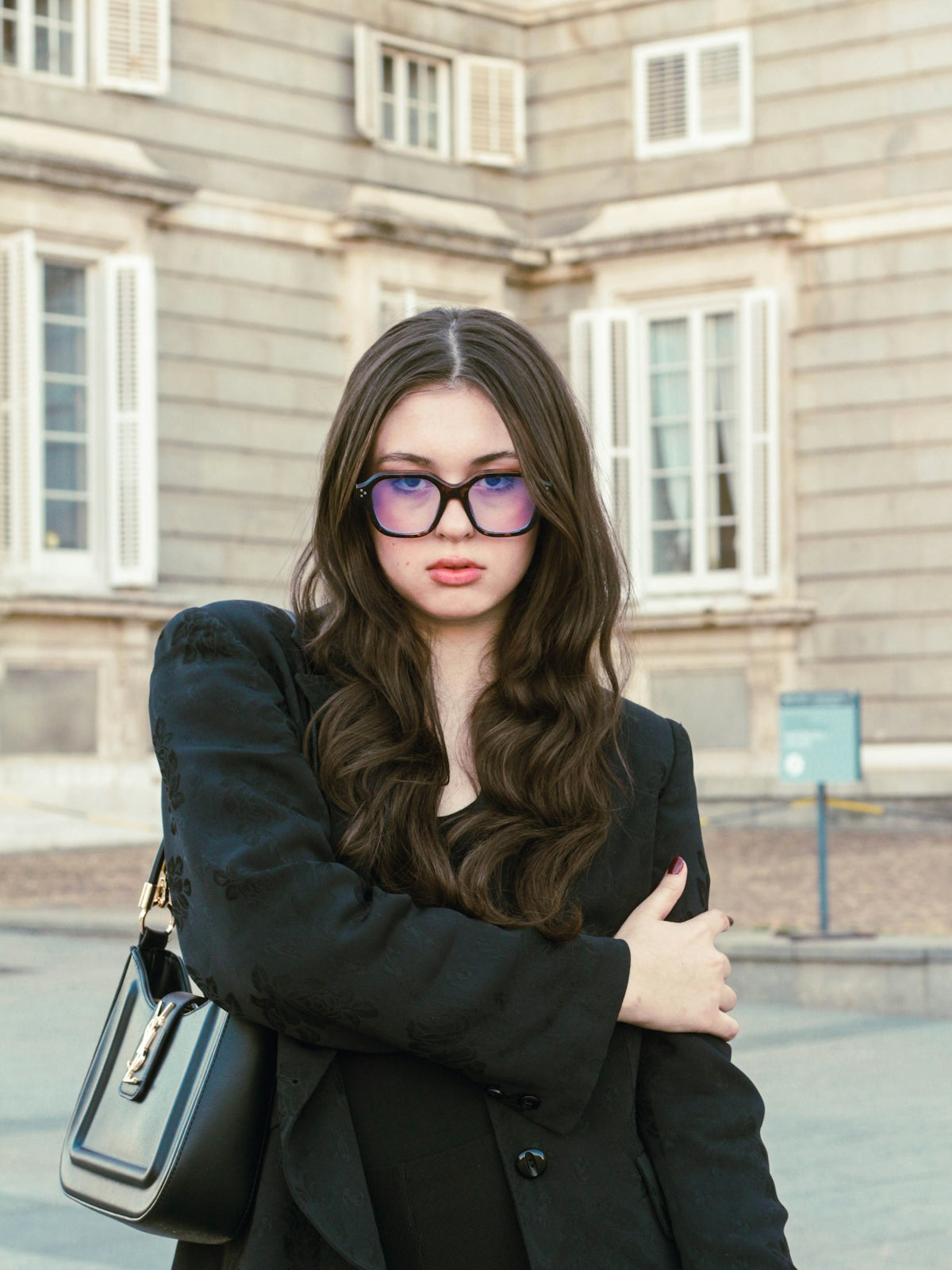 Young woman with glasses and black jacket outdoors