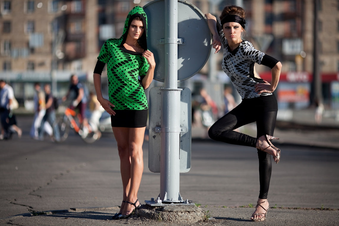Two fashionable women posing on a city street.